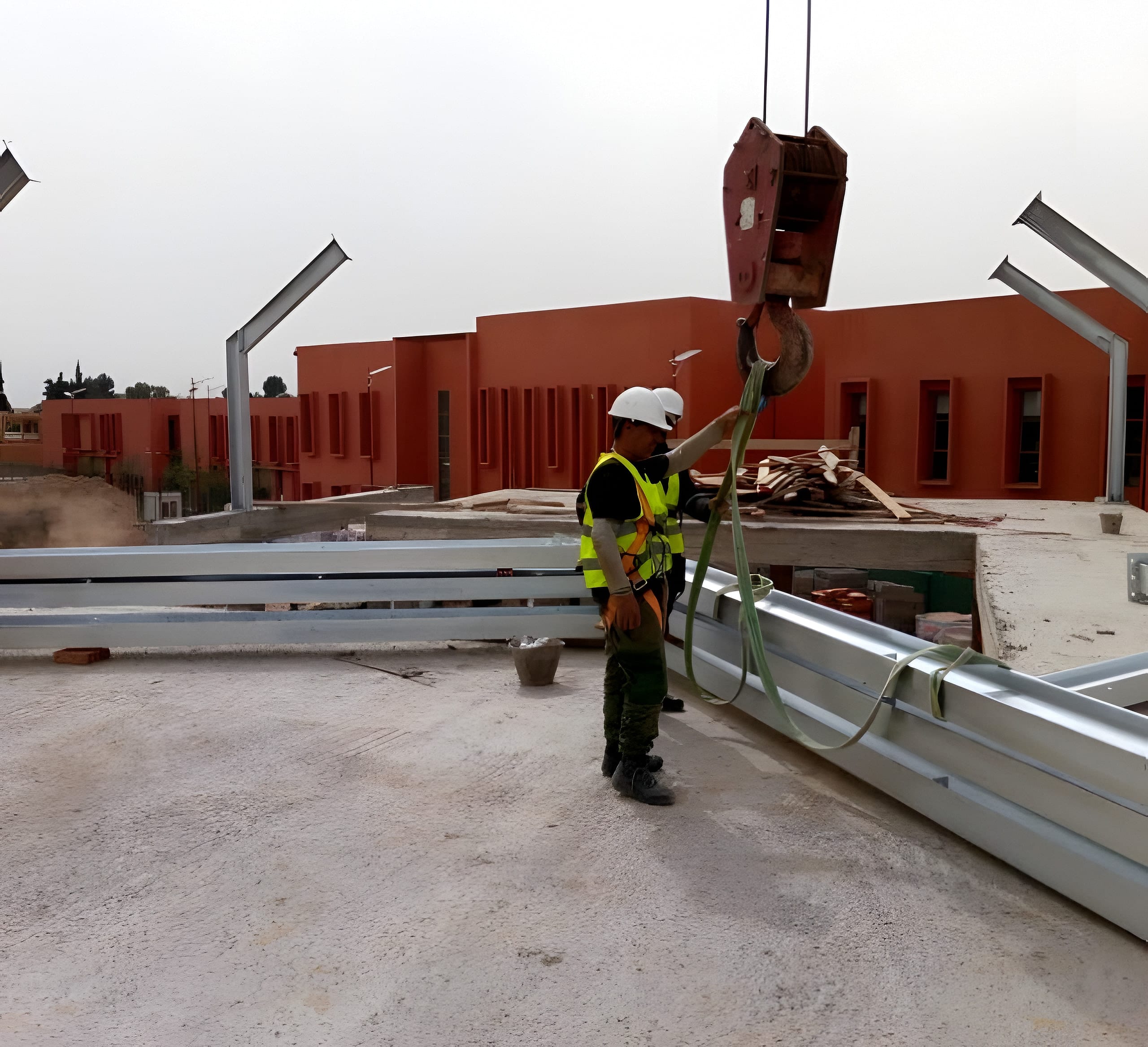 Monteur guidant une poutre métallique au levage sur le chantier UM6P à Benguerir