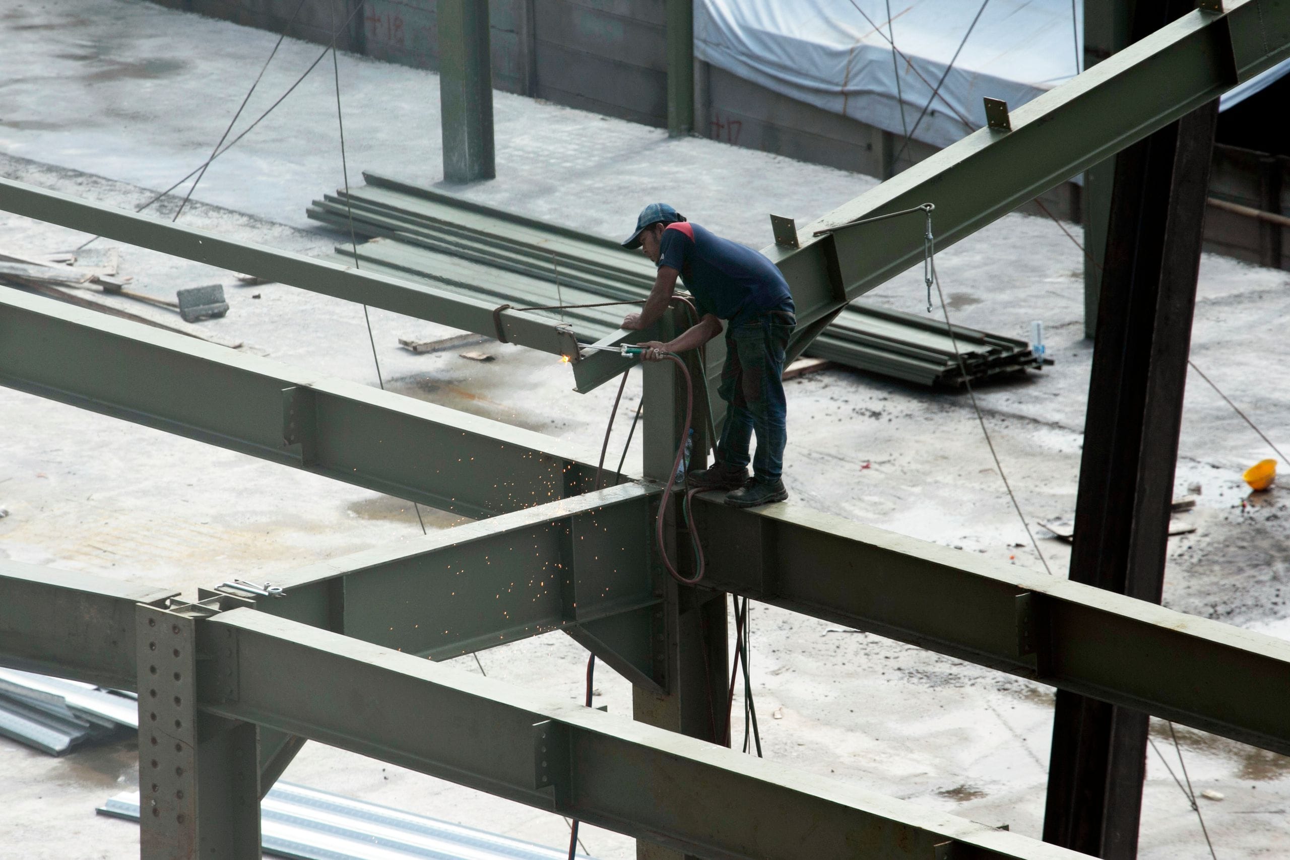 Monteur soudant des poutres en acier sur une structure en cours de montage